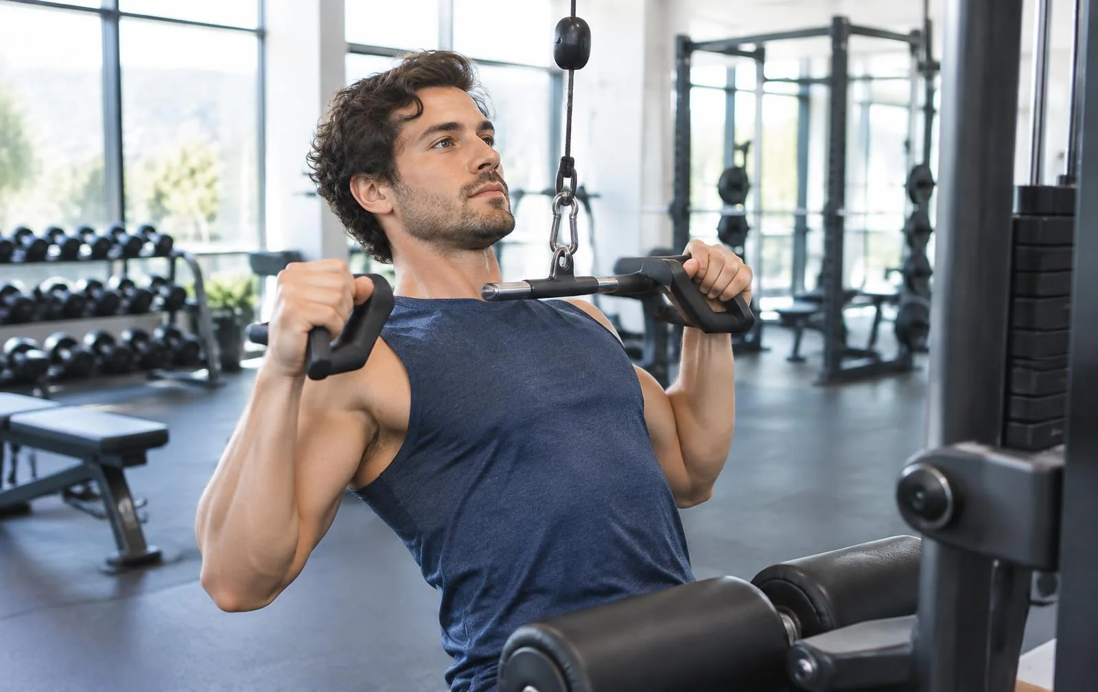 A man performing a controlled neutral-grip lat pulldown.